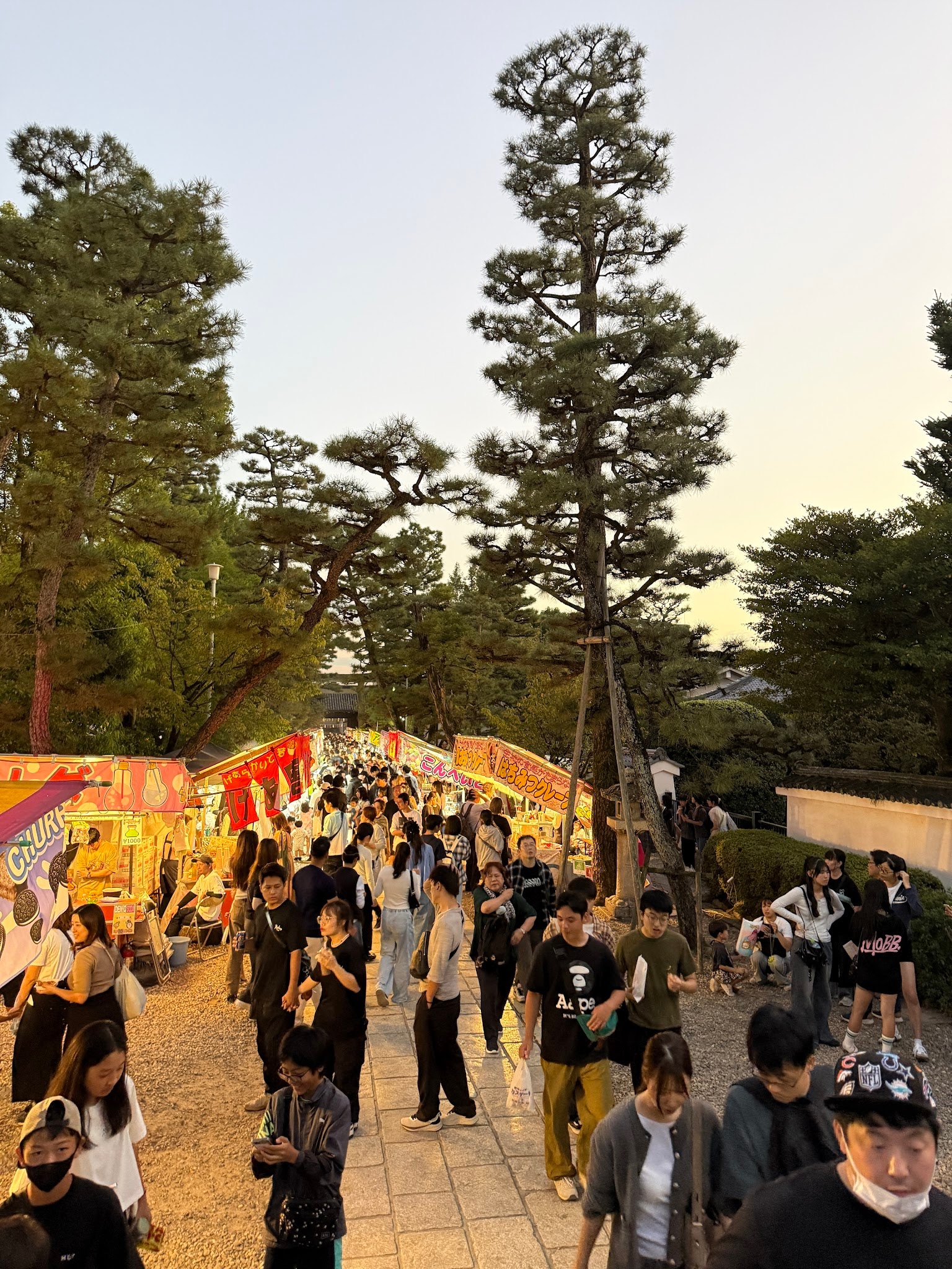 黃昏燈光下，御香宮神社境內攤位之間密集往來的人群