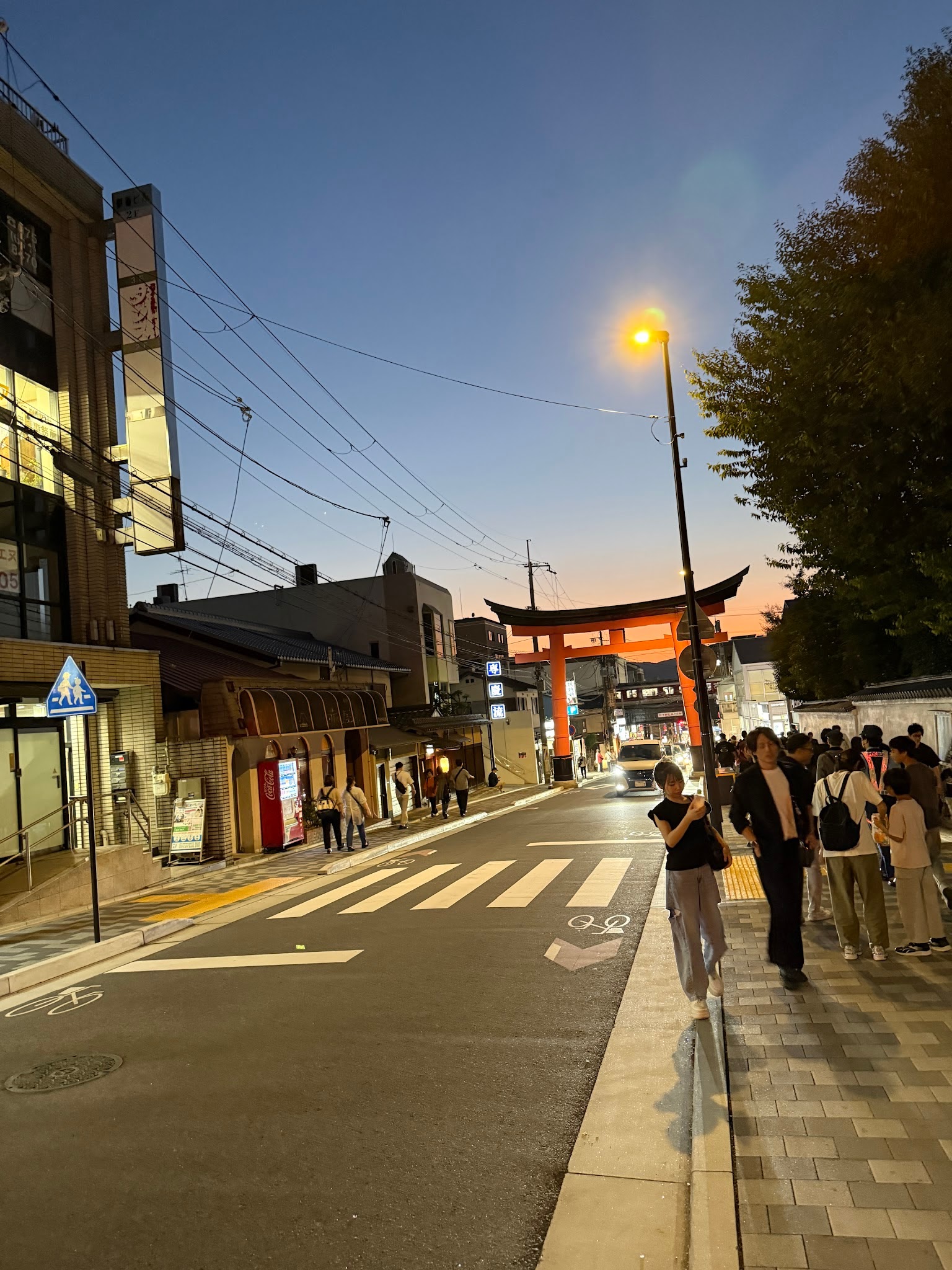 黃昏時分，御香宮神社外的朱紅鳥居、街道與等待祭典的人群
