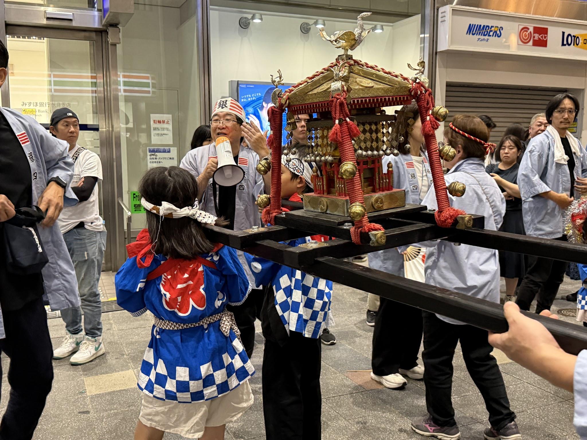 大手筋商店街裡，祭典參與者抬著金色神轎前進